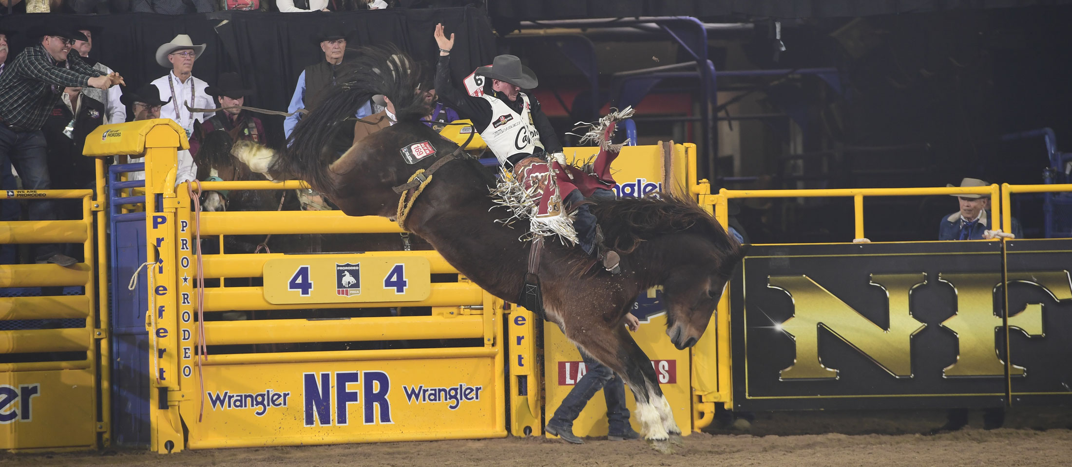 Un vaquero montando a caballo en un rodeo.